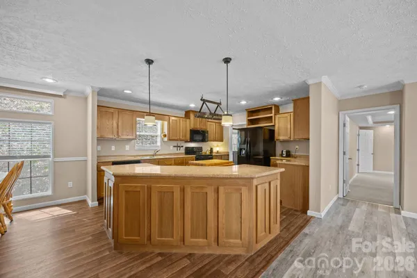 a kitchen with stainless steel appliances granite countertop a refrigerator a stove and a sink with wooden floor