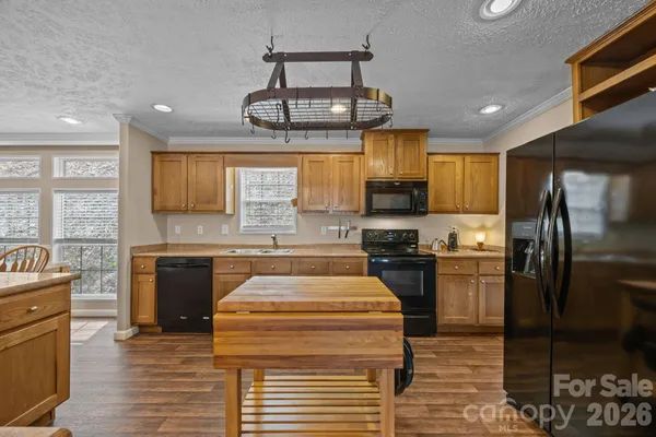 a kitchen with stainless steel appliances granite countertop a sink a stove cabinets counter space and a window