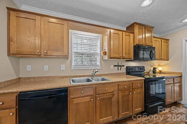 a kitchen with stainless steel appliances granite countertop a sink stove and cabinets