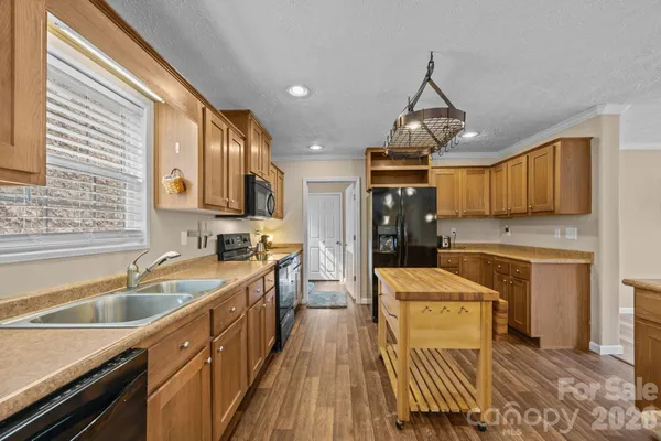 a kitchen with stainless steel appliances granite countertop a sink a stove and cabinets