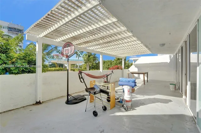 a view of a patio with a table and chairs under an umbrella