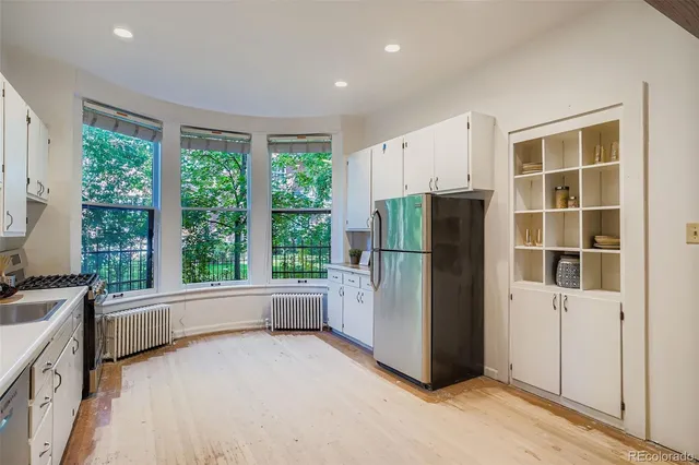 a spacious bedroom with a bed and glass window