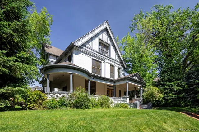 a front view of a house with a yard and trees