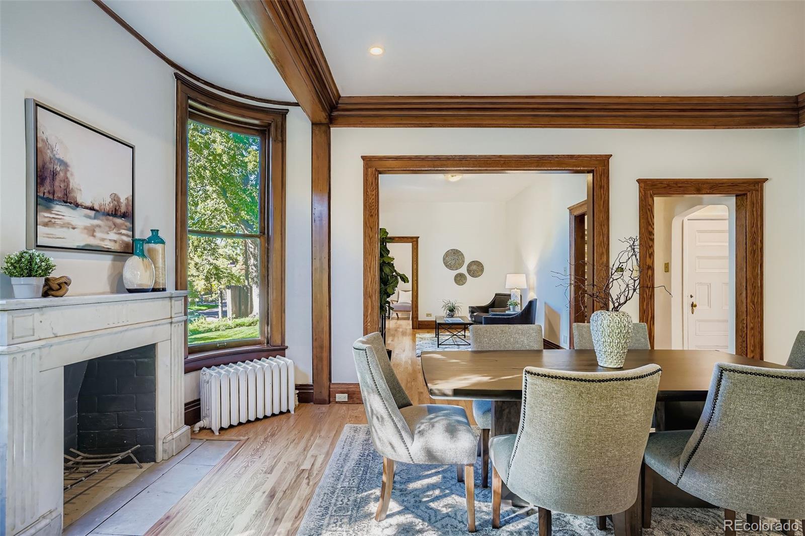 707 Corona Street Denver, CO 80218 - Photo 7 of 46 a dining room with furniture a fireplace and wooden floor
