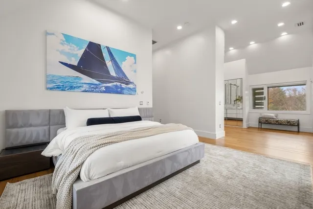 a spacious bedroom with a bed and glass walk in closet