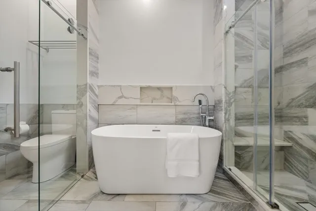 a white bath tub sitting next to a shower