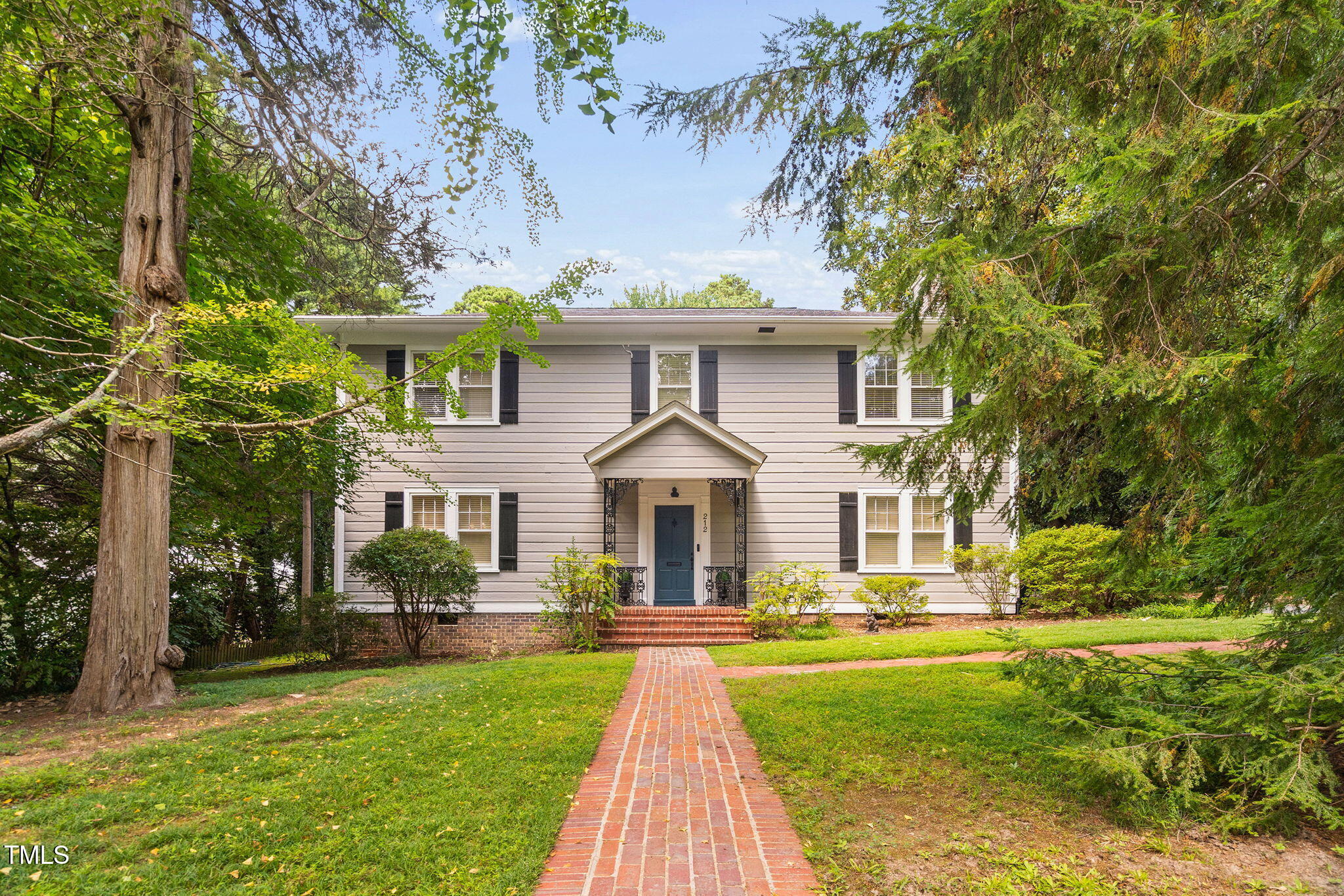 a front view of a house with yard and green space