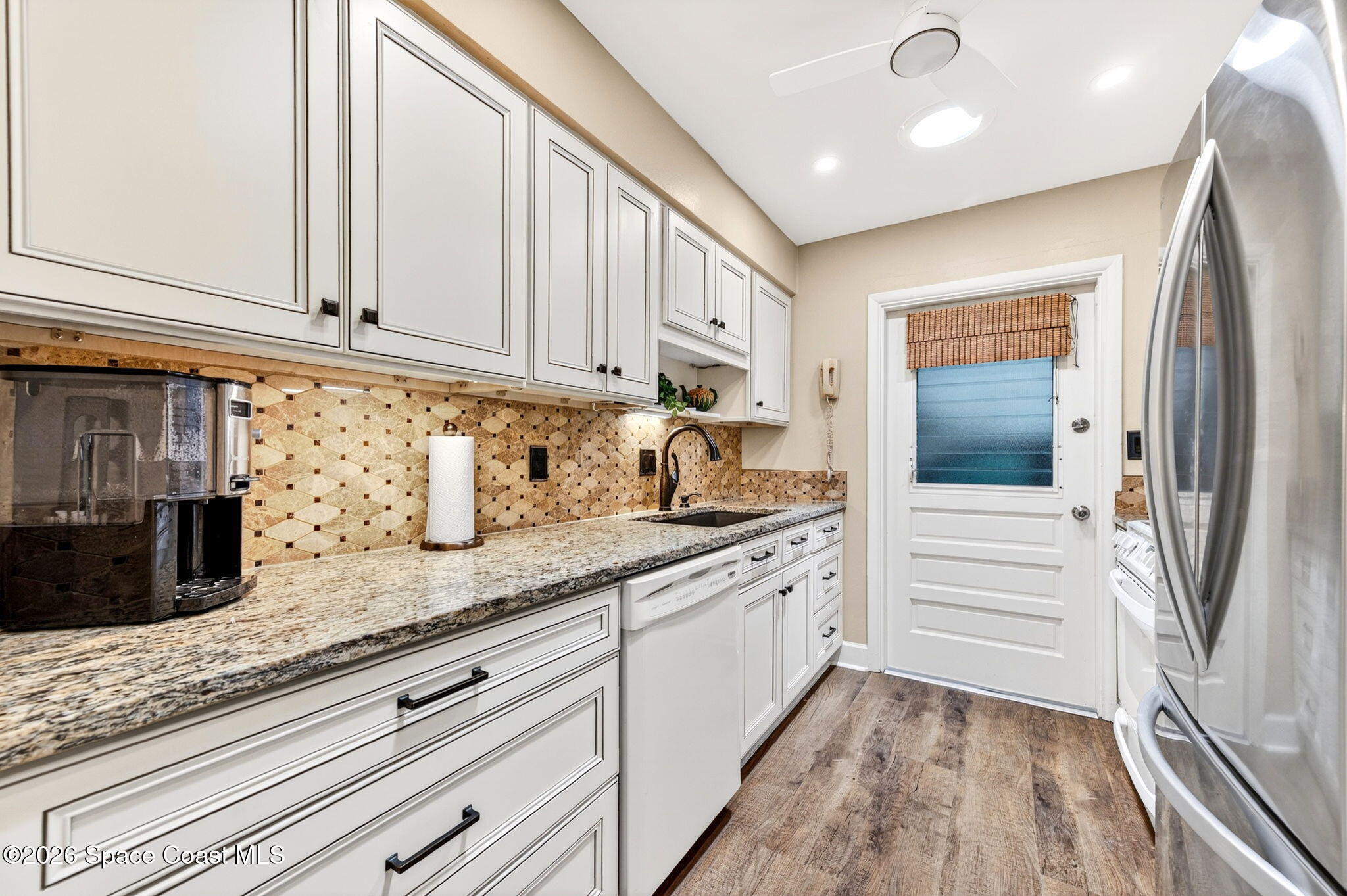 935 Samar Road Cocoa Beach, FL 32931 - Photo 9 of 22 a kitchen with granite countertop white cabinets and stainless steel appliances