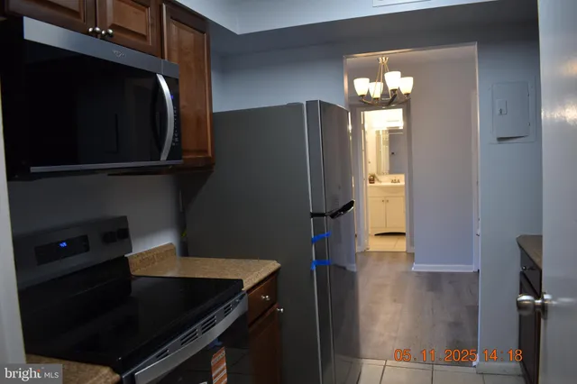 a kitchen with a refrigerator and a stove top oven