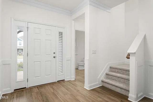 an empty room with wooden floor and entryway