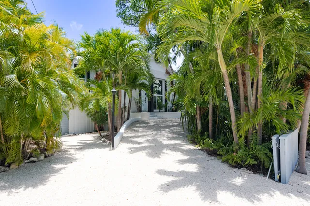 a living room with furniture and a flat screen tv with kitchen view