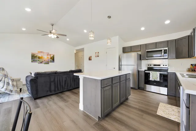 an open kitchen with granite countertop a sink and chairs