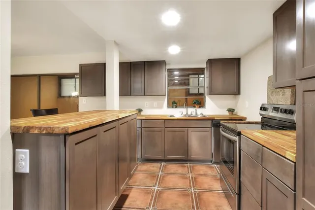 a kitchen with stainless steel appliances granite countertop a refrigerator and a stove