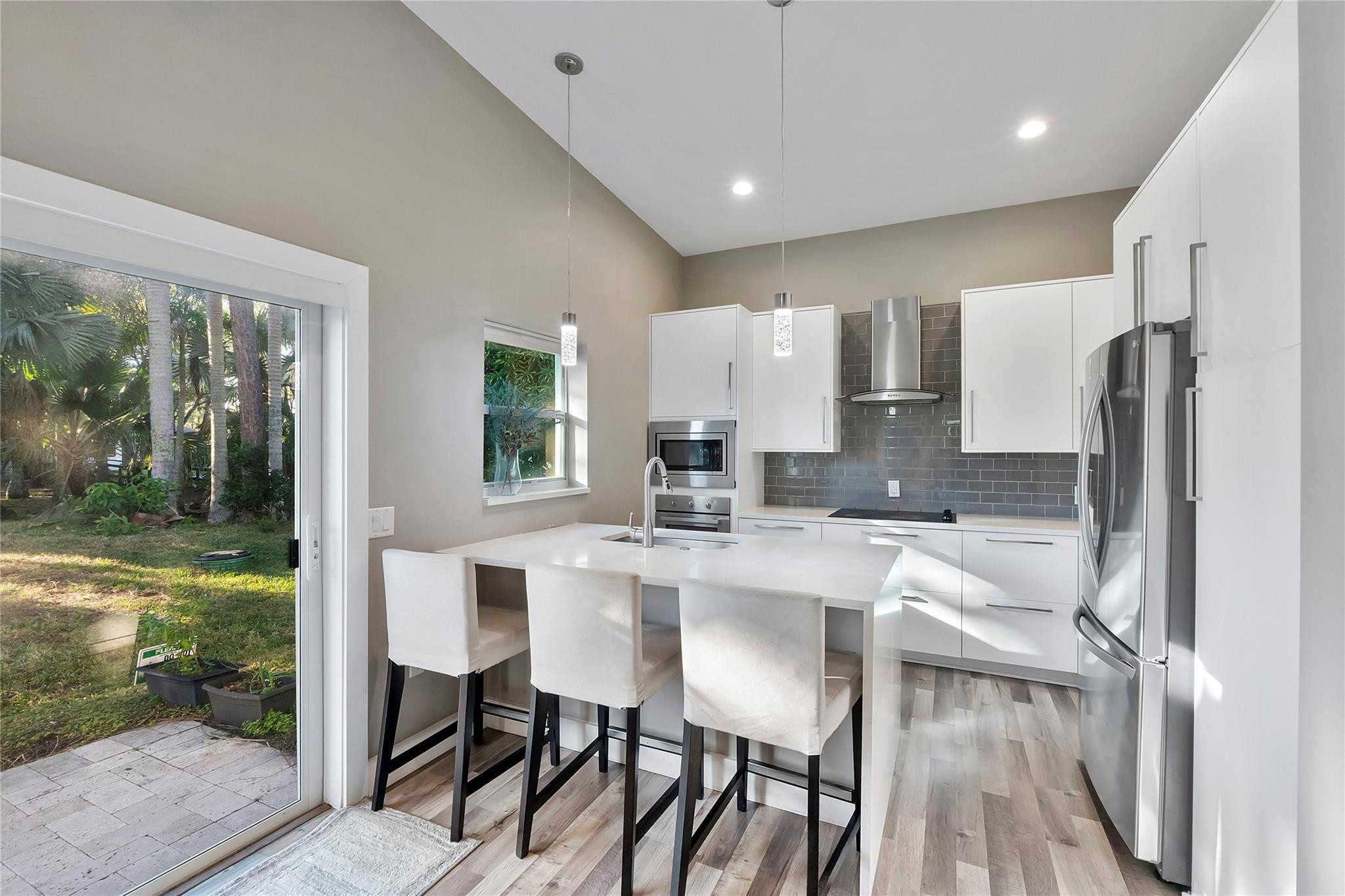 5351 Godfrey Road Parkland, FL 33067 - Photo 74 of 95 a kitchen with kitchen island a table and chairs