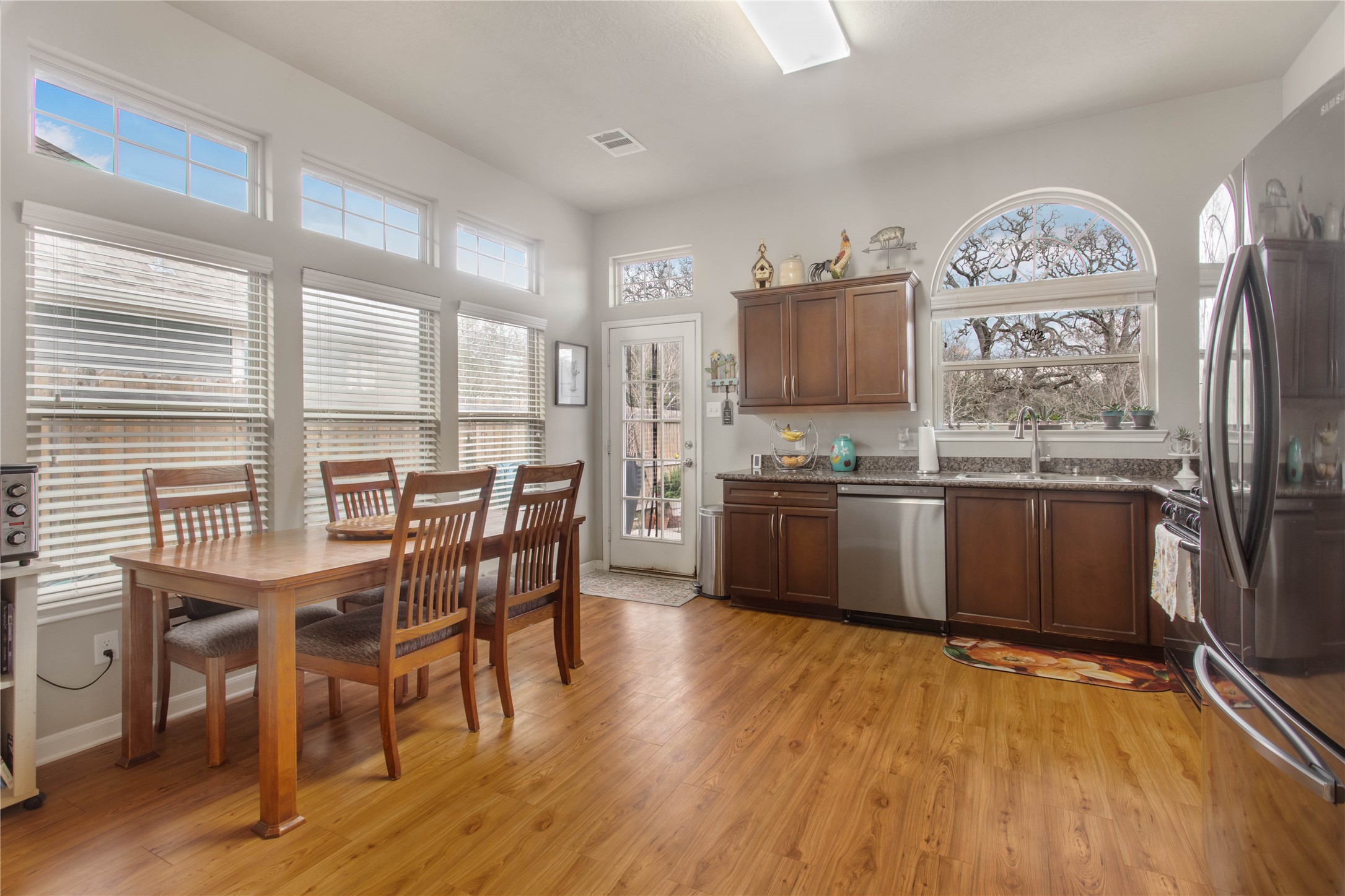 15416 Baker Meadow Loop College Station, TX 77845 - Photo 6 of 26 a kitchen with stainless steel appliances granite countertop a stove top oven a sink dishwasher and white cabinets with wooden floor