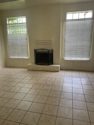 a view of an empty room with a fireplace and a window