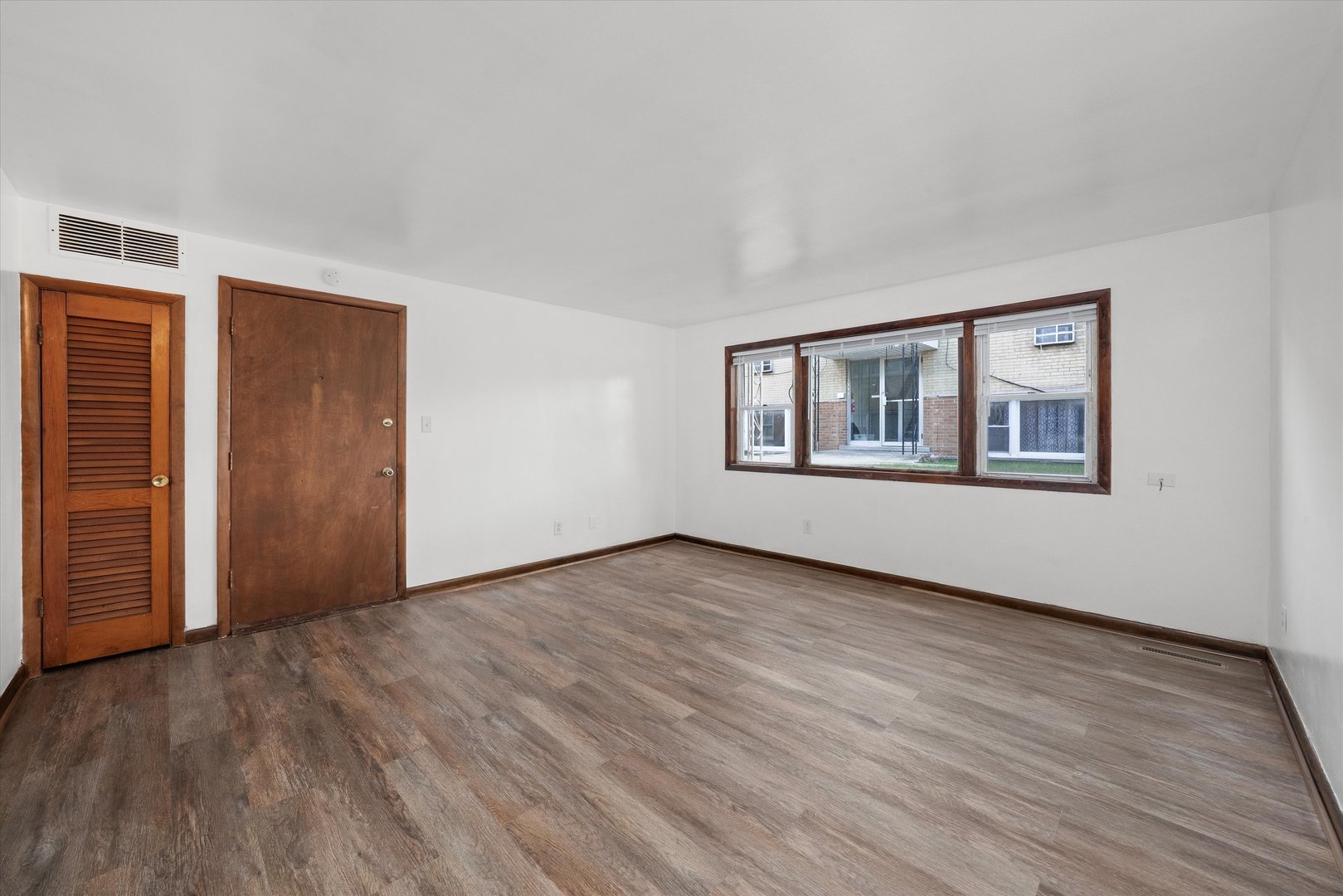 18508 Torrence Avenue Lansing, IL 60438 - Photo 12 of 39 a view of an empty room with wooden floor and a window