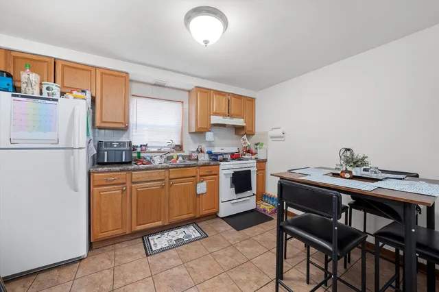a kitchen with granite countertop cabinets and white appliances