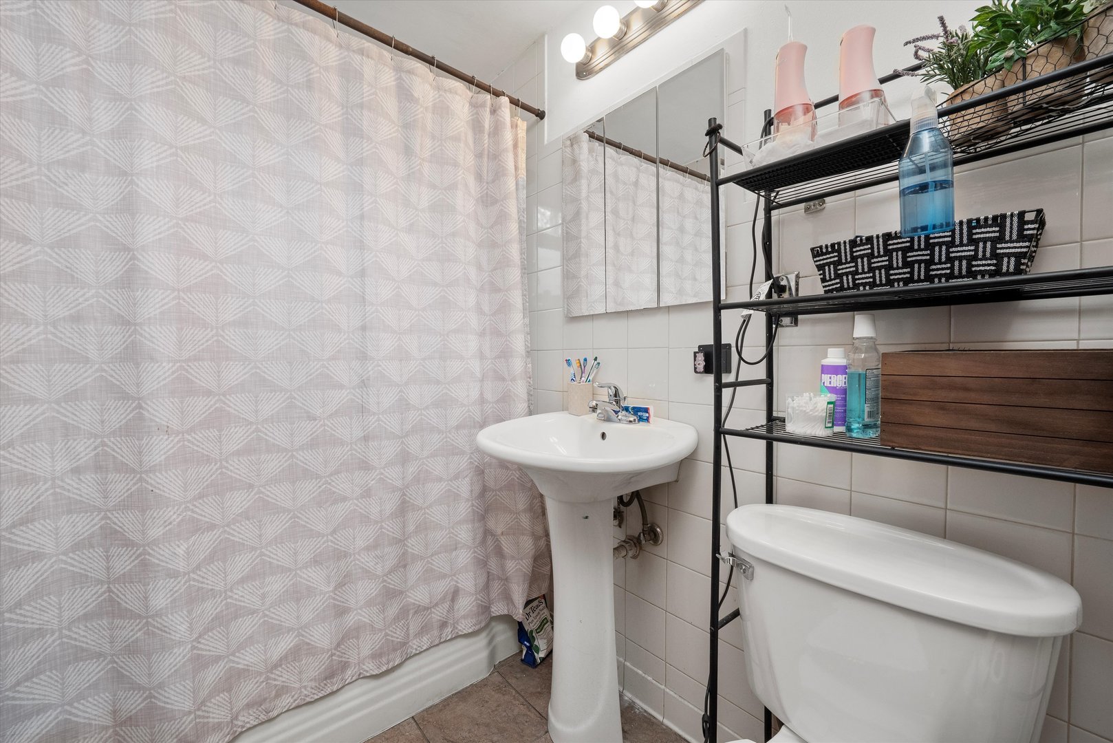 18508 Torrence Avenue Lansing, IL 60438 - Photo 22 of 39 a bathroom with a sink a toilet and shower curtain