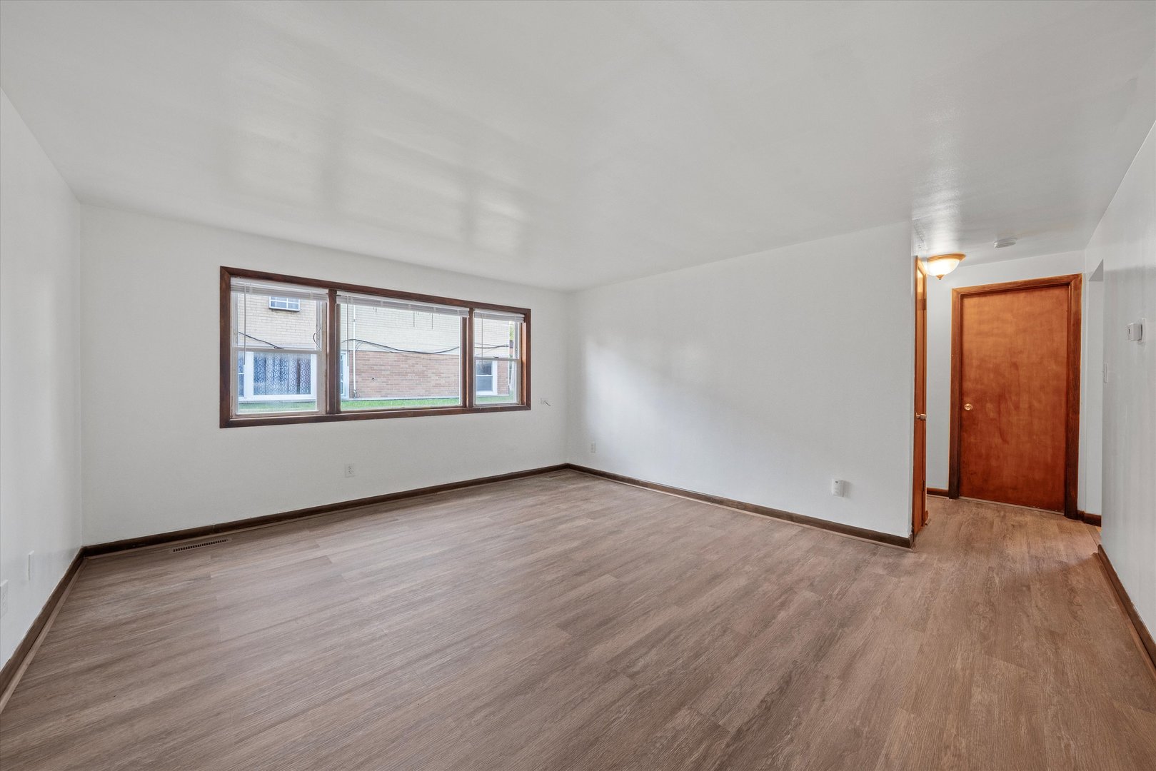18508 Torrence Avenue Lansing, IL 60438 - Photo 3 of 39 an empty room with wooden floor and windows