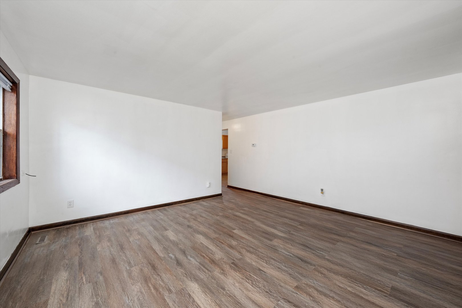 18508 Torrence Avenue Lansing, IL 60438 - Photo 5 of 39 a view of an empty room with wooden floor and a window