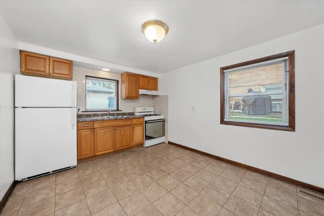 a kitchen with stainless steel appliances a refrigerator and a stove top oven