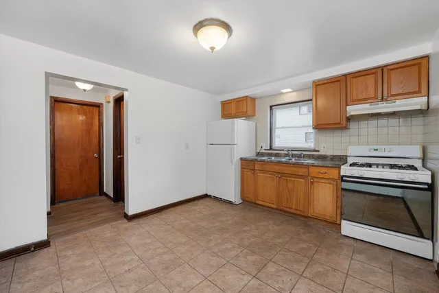 a kitchen with granite countertop a stove top oven sink and cabinets