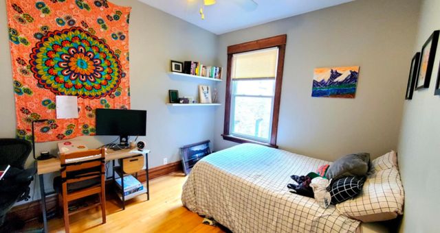 a bedroom that has a bed and a computer on a table