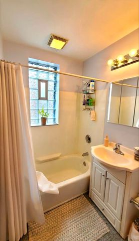 a bathroom with a tub sink and mirror