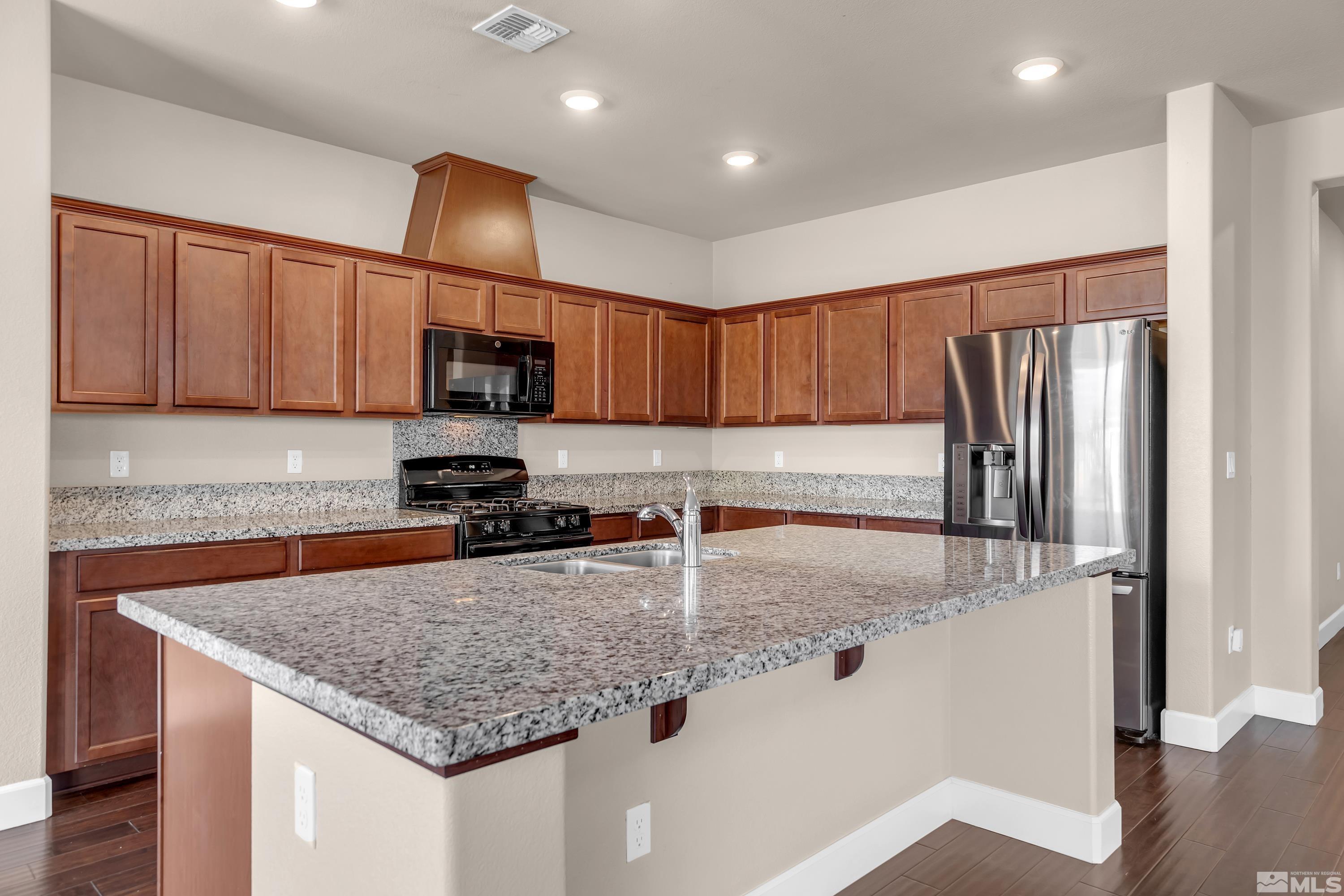 9352 Bay Drive Reno, NV 89506 - Photo 5 of 37 a kitchen with stainless steel appliances granite countertop a sink refrigerator and microwave