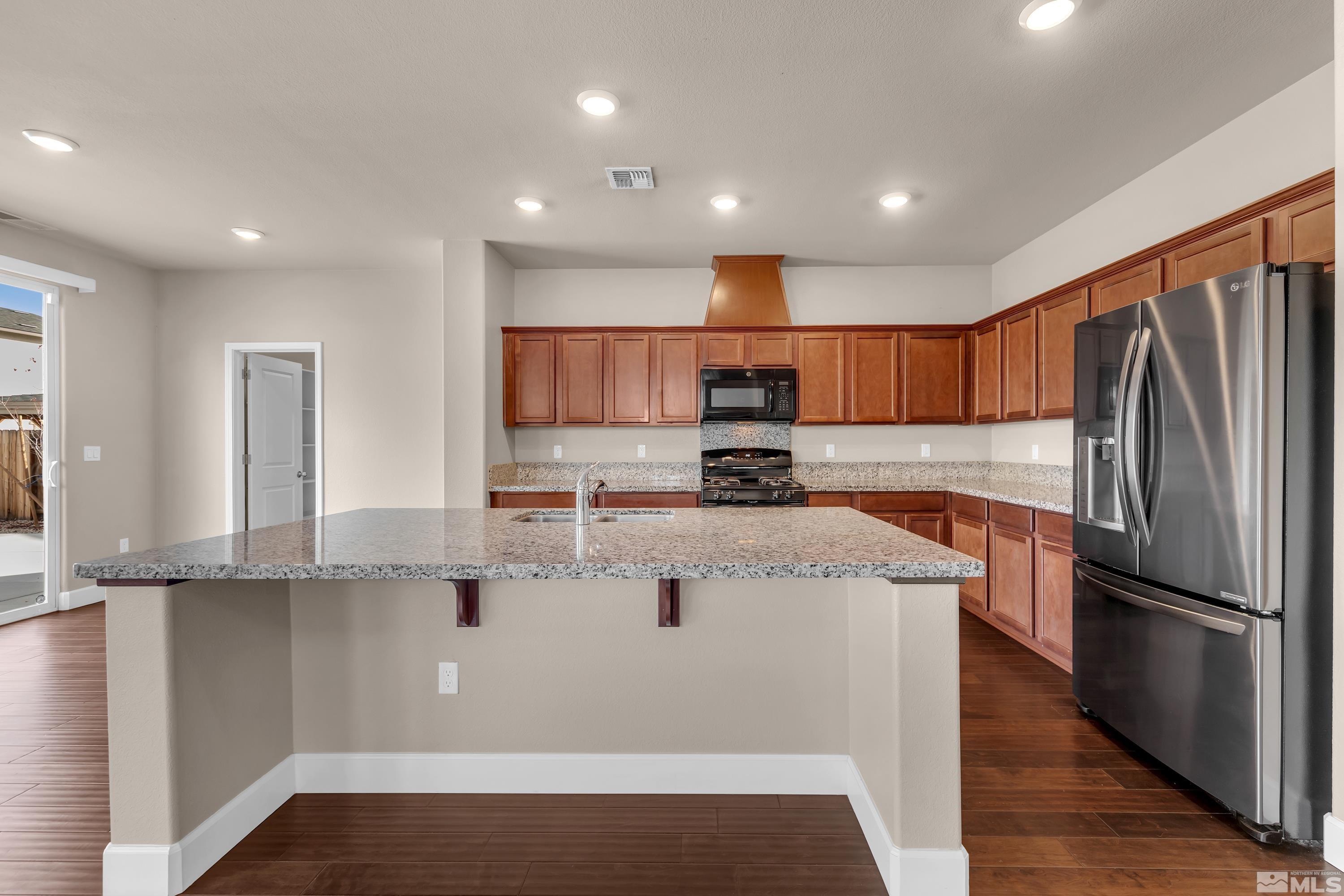 9352 Bay Drive Reno, NV 89506 - Photo 7 of 37 a kitchen with stainless steel appliances granite countertop a refrigerator a stove and a sink