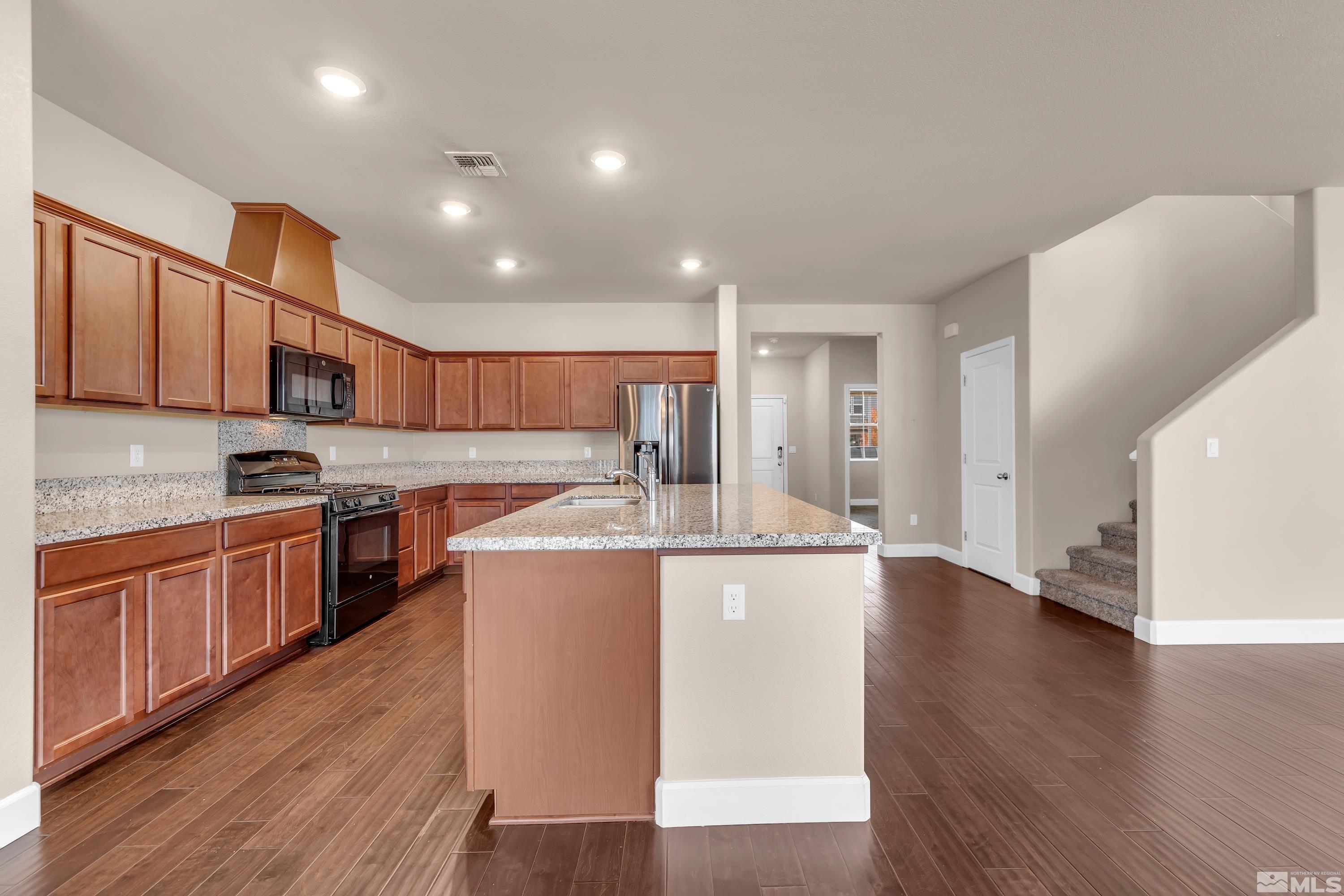 9352 Bay Drive Reno, NV 89506 - Photo 10 of 37 a large kitchen with stainless steel appliances granite countertop a large stove a sink dishwasher and a refrigerator with wooden floor