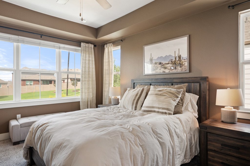 7403 Travertine Spring Drive, Unit 117 Austin, TX 78744 - Photo 5 of 37 Well-lit sleeping quarters with a ceiling fan, plush carpeting, and views of the surrounding neighborhood.