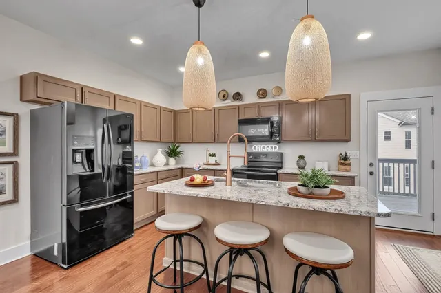a kitchen with stainless steel appliances granite countertop a sink a stove and refrigerator