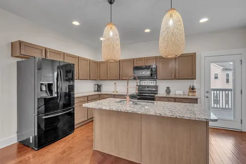 a kitchen with stainless steel appliances granite countertop a sink refrigerator and cabinets