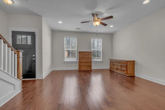a view of a kitchen with a stove wooden cabinet a kitchen wooden floor and chandelier