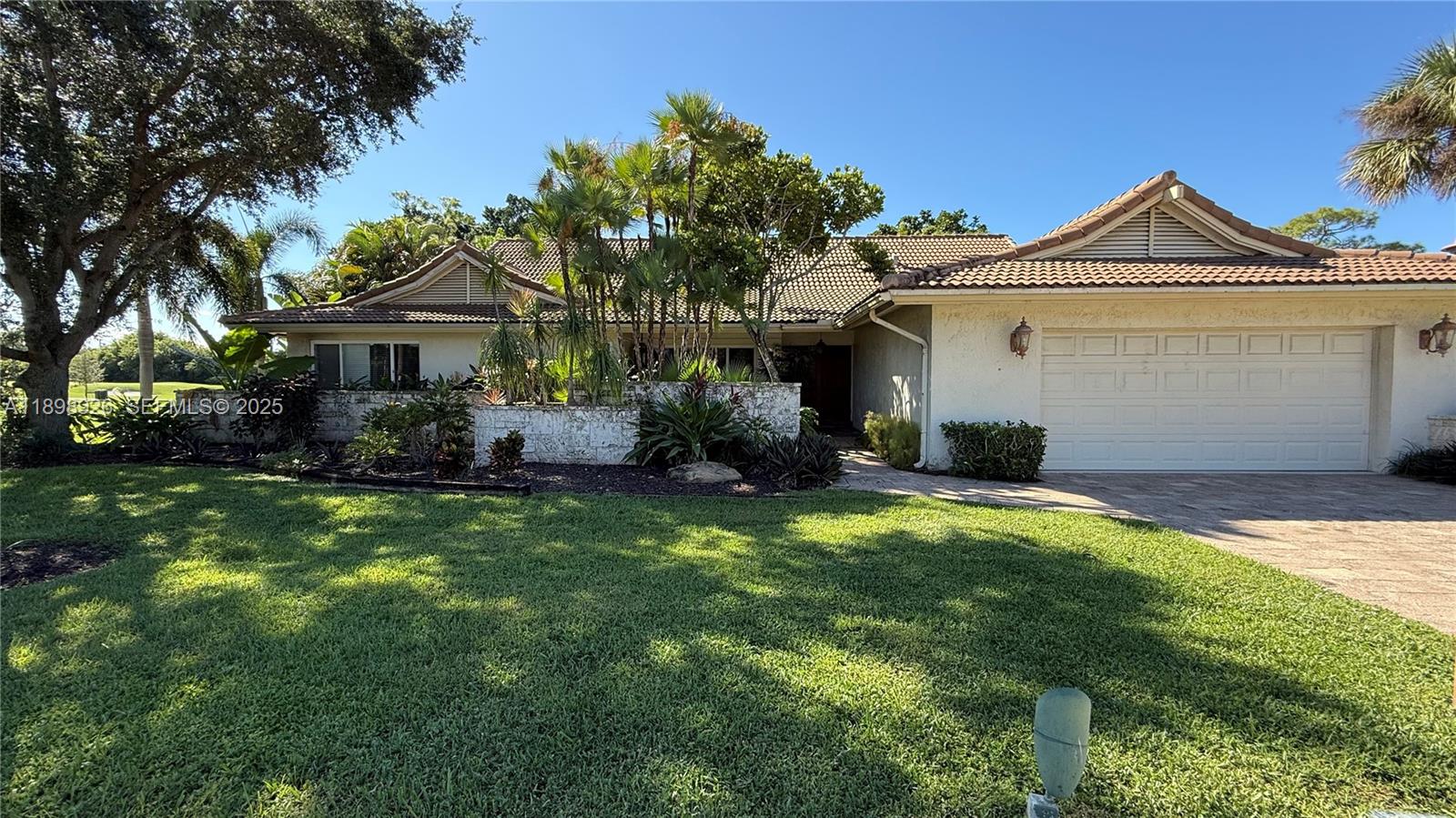 10134 Boca Woods Lane, Unit 10134 Boca Raton, FL 33428 - Photo 12 of 17 a front view of a house with a garden and plants
