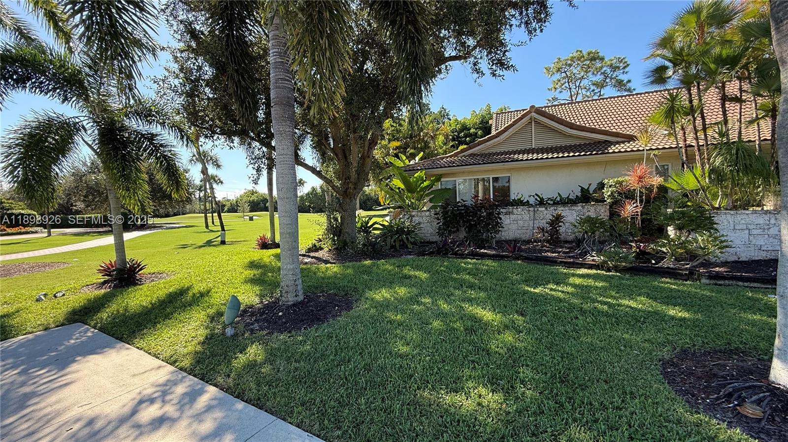10134 Boca Woods Lane, Unit 10134 Boca Raton, FL 33428 - Photo 14 of 17 a view of a house with a yard