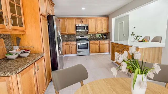 a kitchen with stainless steel appliances granite countertop a refrigerator a stove a sink dishwasher and cabinets with wooden floor