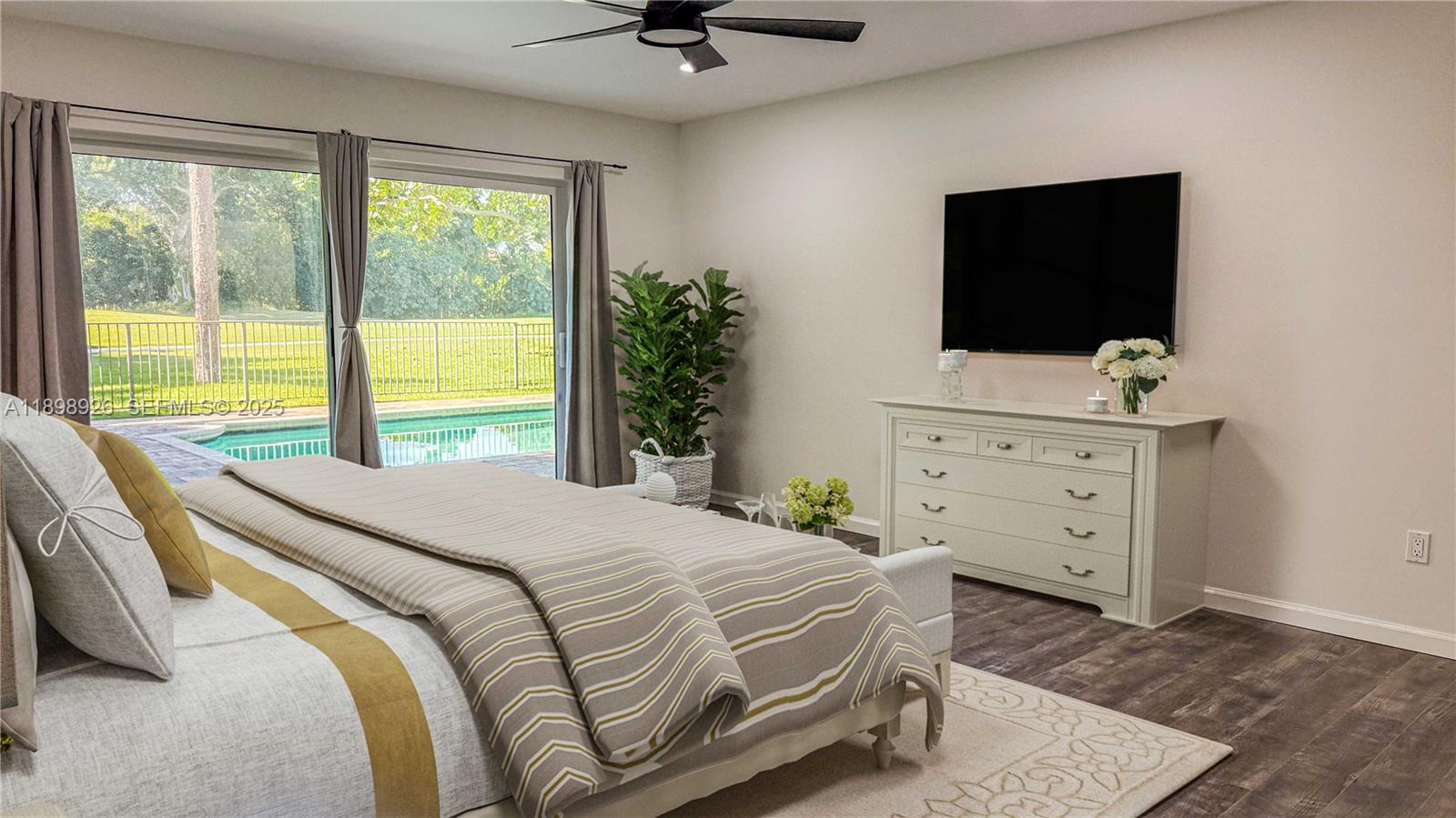 10134 Boca Woods Lane, Unit 10134 Boca Raton, FL 33428 - Photo 5 of 17 a bedroom with a bed and a flat screen tv