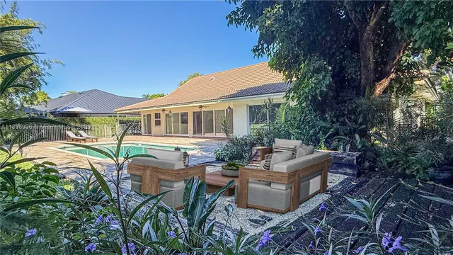 a view of a patio with couches table and chairs and potted plants
