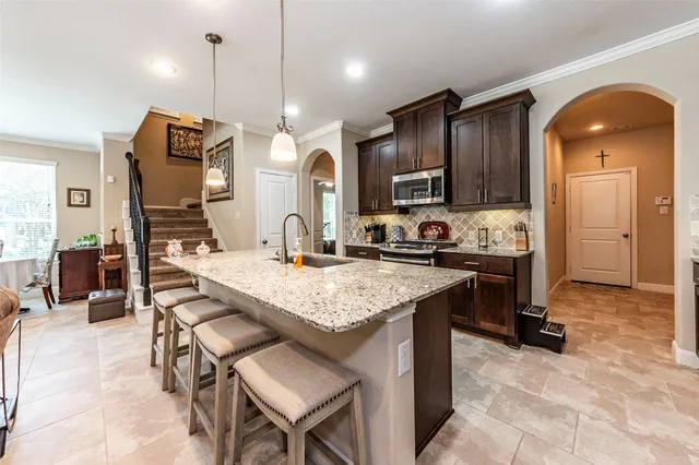 a kitchen with a sink a counter space appliances and cabinets