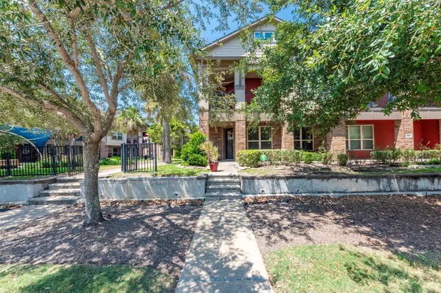 a front view of a house with a yard and tree s