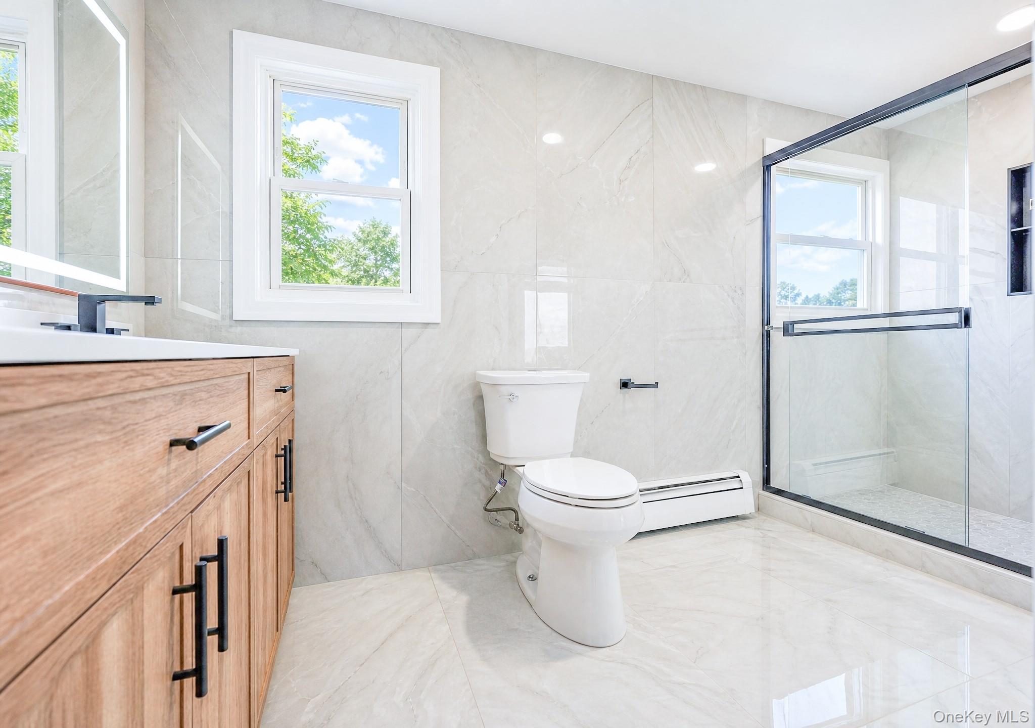 61 Cheshire Road Bethpage, NY 11714 - Photo 17 of 25 Bathroom featuring a wood-finish vanity with matte black hardware, white rectangular sink, and wall-mounted faucet