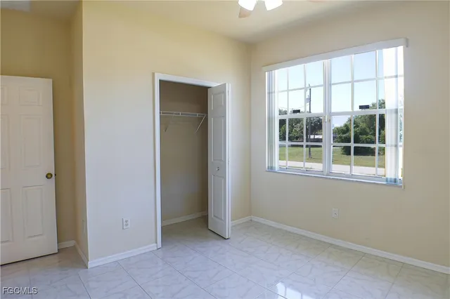 an empty room with windows and closet