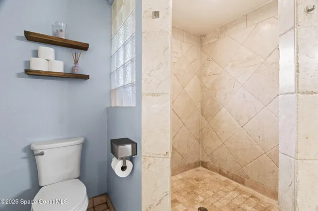 a bathroom with a toilet and a shower curtain