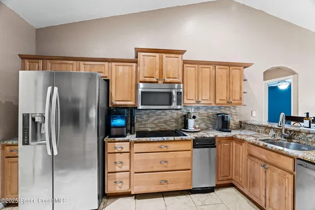 a kitchen with stainless steel appliances granite countertop a refrigerator sink and cabinets