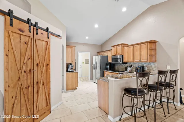a kitchen with stainless steel appliances a refrigerator and a stove top oven