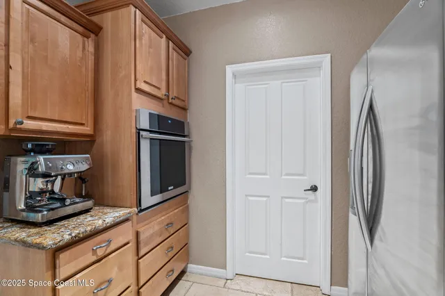 a kitchen with stainless steel appliances granite countertop a refrigerator and a stove top oven