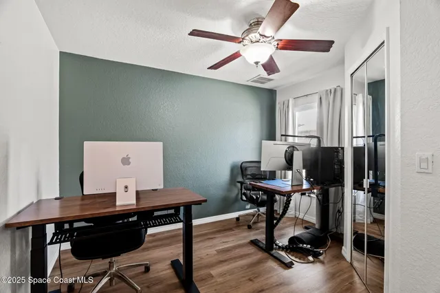a view of a workspace with furniture and wooden floor